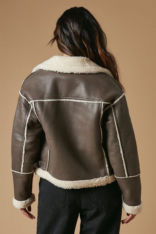 Striking contrast borg detailing for added warmth and style
        Asymmetrical zip front closure for a modern edge
        Oversized collar for a bold, fashion-forward look
        Cropped length perfect for layering
        Versatile design suitable for various casual occasions
    
    This PU borg detail collared zip jacket from Oasis is the epitome of cool-weather chic. The contrasting borg lining not only adds a cosy touch but also creates a striking visual appeal. Its asymmetrical zip closure and oversized collar lend a contemporary edge to your ensemble. The cropped silhouette is ideal for showcasing high-waisted bottoms, as demonstrated by the model pairing it with wide-leg trousers. For a casual day out, style it with your favourite jeans and trainers. Alternatively, dress it up for an evening with friends by layering it over a fitted dress and ankle boots. This jacket is a versatile piece that will quickly become a go-to in your autumn and winter wardrobe, perfect for family gatherings, weekend brunches, or casual outings where you want to make a stylish statement without compromising on comfort.