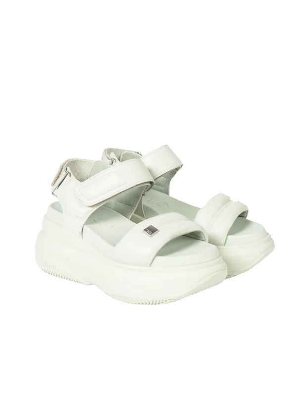 Estas sandalias de moda con suela gruesa son la elección perfecta para aquellos que valoran la comodidad y el estilo; su sólida suela amortiguadora asegura confort durante todo el día.

El cierre ajustable con velcro no solo garantiza un ajuste perfecto al pie, sino que también permite ponerse y quitarse las sandalias rápidamente y con facilidad, lo cual es extremadamente práctico en días calurosos.

En la parte delantera, hay un emblema de la marca característico con el logo de la empresa, que agrega elegancia a las sandalias y está sutilmente incorporado en su diseño, indicando la originalidad y el alto estatus de la marca.

La suela con logo no solo demuestra la autenticidad del producto, sino que también está diseñada de manera que asegure adherencia y seguridad en diversas superficies.

Hechas de material de alta calidad, estas sandalias son resistentes al desgaste y daños, lo que asegura su uso prolongado y mantiene su apariencia estética a lo largo de muchas temporadas.