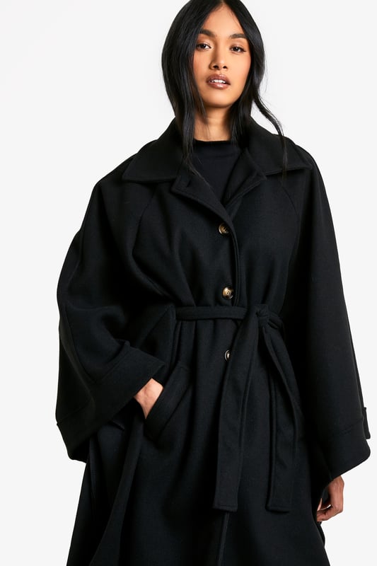 Dramatic cape-style silhouette for a bold statement
        Oversized collar adds a touch of sophistication
        Belted waist for a customisable fit
        Functional side pockets for practicality
        Versatile length suitable for various outfits
    
    Make a striking entrance with this captivating cape in wool-look fabric. Perfect for the fashion-forward woman who craves both style and comfort, this piece effortlessly combines drama with versatility. The oversized collar and flowing silhouette create an air of elegance, while the belted waist allows you to customise your look. Ideal for casual outings or family gatherings, pair it with wide-leg trousers and a simple top for a chic ensemble. The side pockets add a practical touch, making it perfect for those days when you want to travel light. Whether you're heading to a coffee date or a weekend market, this cape will ensure you stand out from the crowd while keeping you cosy. Its adaptable nature means it can be dressed up or down, making it a valuable addition to any wardrobe.