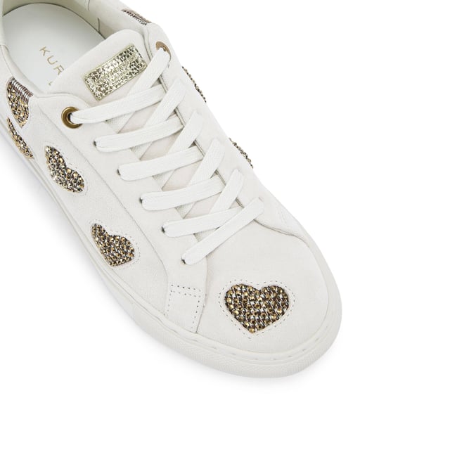 The Kurt Geiger Lane Love sneaker is crafted from a white leather with crystal embellished fabric hearts across the upper. There are two gold leather patches on the tongue and heel with gold foil branding.