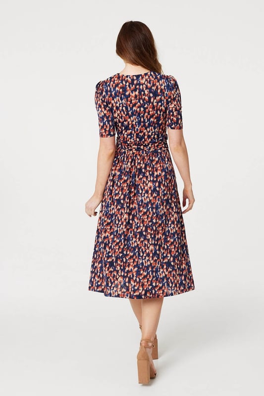 Add a comfortable jersey dress to your wardrobe with this printed midi. It has a v-neck with a faux wrap front, 1/2 sleeves, a flattering ruched waist and a straight midi length skirt. Pair with heels or boots for a go-to style to wear during transitional seasons.