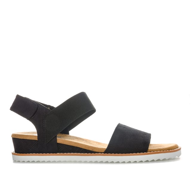 Women's Skechers BOBS Desert Kiss Sandals in Black Womens Skechers BOBS Desert Kiss Sandals in black. Strappy casual comfort sandals.- Soft and smooth durasuede fabric upper.- Bandage strap to front with perforated detail.- Elasticated instep ankle strap for flexible comfort.- Slingback ankle strap with hook and loop fastening for a custom fit. - Smooth fabric strap lining. - Memory Foam cushioned comfort insole.- Durasuede wrapped low wedge midsole with perforated detail. - Flexible traction outsole. - Wedge height: 3cm (1.25“) approximately.- Textile upper and lining Synthetic sole. - Ref: 31440-BLKMeasurements are intended for guidance only.