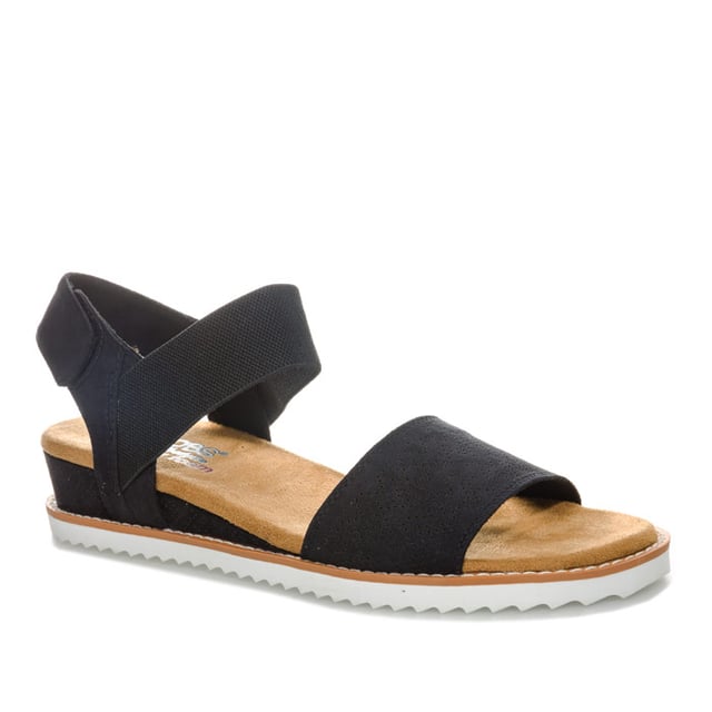 Women's Skechers BOBS Desert Kiss Sandals in Black Womens Skechers BOBS Desert Kiss Sandals in black. Strappy casual comfort sandals.- Soft and smooth durasuede fabric upper.- Bandage strap to front with perforated detail.- Elasticated instep ankle strap for flexible comfort.- Slingback ankle strap with hook and loop fastening for a custom fit. - Smooth fabric strap lining. - Memory Foam cushioned comfort insole.- Durasuede wrapped low wedge midsole with perforated detail. - Flexible traction outsole. - Wedge height: 3cm (1.25“) approximately.- Textile upper and lining Synthetic sole. - Ref: 31440-BLKMeasurements are intended for guidance only.
