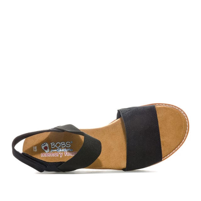 Women's Skechers BOBS Desert Kiss Sandals in Black Womens Skechers BOBS Desert Kiss Sandals in black. Strappy casual comfort sandals.- Soft and smooth durasuede fabric upper.- Bandage strap to front with perforated detail.- Elasticated instep ankle strap for flexible comfort.- Slingback ankle strap with hook and loop fastening for a custom fit. - Smooth fabric strap lining. - Memory Foam cushioned comfort insole.- Durasuede wrapped low wedge midsole with perforated detail. - Flexible traction outsole. - Wedge height: 3cm (1.25“) approximately.- Textile upper and lining Synthetic sole. - Ref: 31440-BLKMeasurements are intended for guidance only.