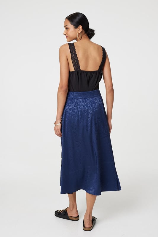 This elegant skirt has a silky satin texture with a flattering a-line cut. It fastens with button details and has a high waist fit, with a midi length hem. Tuck your favourite t-shirt, top or jumper into the waistband for an elevated casual look.