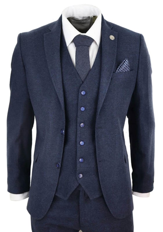 Ein blauer Anzug ist ein Grundbestandteil der Garderobe eines jeden Mannes und dieser hier ist keine Ausnahme von dieser ungeschriebenen Regel. Scharf, elegant und raffiniert – sehen Sie gut aus mit diesem hochwertigen dreiteiligen marineblauen Woll-Tweed-Anzug mit Slim-Fit-Schnitt, engerer Passform an der Brust und schmaler geschnittenen Hosen. Die Zwei-Knopf-Jacke fällt wunderschön und hat eine halbe Canvas-Konstruktion, die sich Ihrer Körperform anpasst, je mehr Sie sie tragen. Mit Taschenpaspeln aus Samt, geknöpften Manschetten und einem einzelnen Rückenschlitz verleihen dem Anzug einen klassischen Hauch von Raffinesse. Eine passende Tweedweste vervollständigt den Dreiteiler im einreihigen Daunenstil mit klassischen maßgeschneiderten Taschen und einem Rückenversteller, um sicherzustellen, dass Sie Ihre ideale Passform kreieren können. Der Anzug ist immergrün und zeitgemäß zugleich und ermöglicht es Ihnen, den ganzen Tag über gut auszusehen. Kombinieren Sie es mit einer passenden Weste, einem weißen Hemd und Schuhen für ein elegantes Finish.