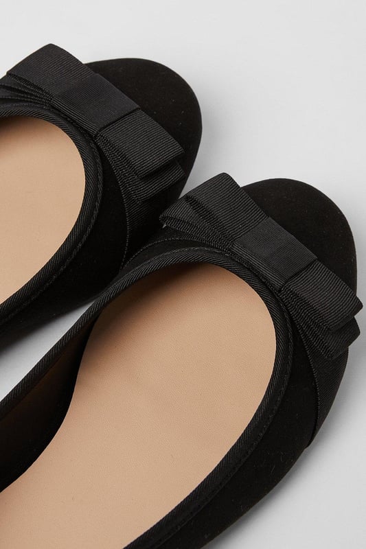 Chic faux leather ballet pumps with a wide fit for added comfort
Elegant bow detail adorns the toe for a feminine touch
Slip-on style for easy on and off
Flat sole provides all-day wearability
faux leather upper with a synthetic lining

These versatile ballet pumps from Dorothy Perkins exude effortless sophistication. The wide fit ensures a comfortable wear, while the bow detail adds a touch of elegance. Pair them with tailored trousers for a polished workwear ensemble or team with a floral dress for a charming daytime look. Perfect for casual events, family gatherings, or meeting friends for brunch, these flats strike the perfect balance between style and comfort.