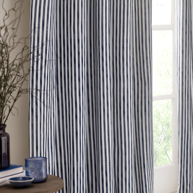 Transform your living space into a sanctuary with Hebden Striped Pencil Pleat Curtains. Crafted from 100% cotton, these curtains offer a soft, yet durable touch. The timeless, textured stripe design complements any minimalist or classic décor, while the room-darkening lining provides the perfect retreat from the outside world. Perfect for those who value natural materials, Hebden curtains are an investment in comfort and style, enriching your home environment without compromise.