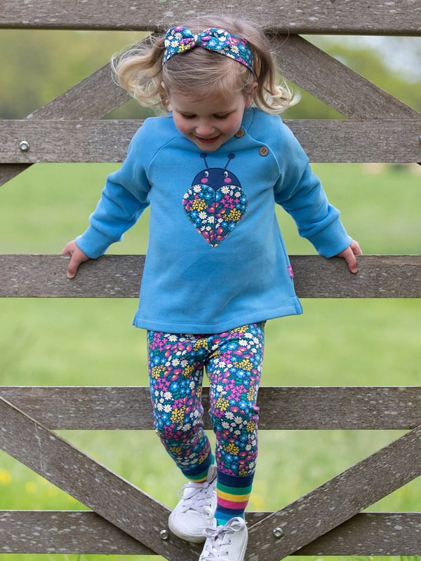 100% organic cotton | Proud to be certified to the Global Organic Textile Standard (GOTS) | Ladybird appliqué design featuring our flower patch print | OEKO-TEX Standard 100 (Product class I) appliqué backing | Cornflower blue | Brush back sweat fabric 3 ply (290-300 gsm) | Coconut button raglan sleeve opening (up to and including size 3 years) | Long sleeved | Round neck | Ribbed neckline and cuffs | Made in Turkey | Machine washable at 40 degrees, or at 30 degrees to be kinder to the planet