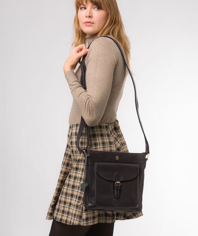 The 'Josephine' shoulder bag from Conkca London is crafted from vegetable-tanned leather for a richly textured finish. The zip-over top conceals a gorgeous, 100% natural, untreated cotton lining and two interior pockets. Featuring a mock buckle, the exterior pocket provides plentiful on-the-go storage. Comes with an adjustable fabric strap and is furnished with gold-coloured metal fittings. Adorned with the inimitable and charming Conkca London squirrel charm and logo for an eye-catching finish.