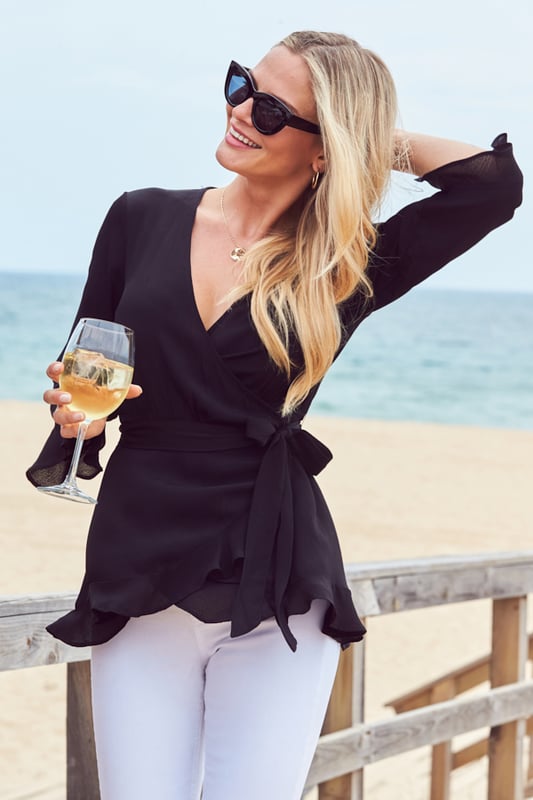 REASONS TO BUY: 

Tops don't get more flattering
Ruffle trim peplum hem
Wrap V-neck, tie back: it's designed for a perfect fit
Statement fluted ruffle trim sleeves
Wear it with white jeans
Try it with shorts and sexy heels