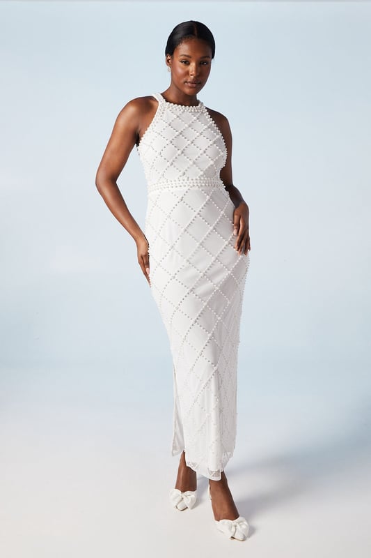 Stunning geometric pearl embellishment
        Elegant halterneck design
        Figure-flattering column silhouette
        Sophisticated midi length
        Delicate hand-stitched detailing
    
    Make a lasting impression on your special day with this exquisite bridal dress from Coast. The intricate geometric pattern adorned with pearls creates a mesmerising visual effect, perfect for the modern bride who desires a touch of glamour. The halterneck style elegantly frames the dcolletage, while the column silhouette gracefully skims your curves. Pair with strappy heels and pearl drop earrings for a cohesive bridal look. This dress is versatile enough for various wedding venues, from a chic city celebration to a romantic beach ceremony. The midi length offers practicality without compromising on style, allowing you to move with ease during your first dance and beyond. This Coast creation is a testament to timeless elegance, ensuring you feel confident and radiant as you embark on your new chapter.