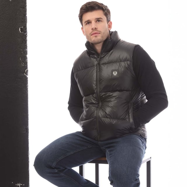 Mens Belstaff Down Filled Ripstop Resolve Gilet in black.- Hood and hem drawcord.- Water resistant double centre front zip.- Zip fastening hip pockets.- Silicone phoenix badge on the chest.- Packable functionality.- 750 fill power down.- 100% RDS certified down and feather (IDFL CERT TE-00103785) with PFAS free water-repellent finish.- High-shine  100% recycled nylon in a micro ripstop construction.- High performance  lofty  ultralight and highly insulating down gilet style.- 100% Polyamide.- Ref: 105160BLACK