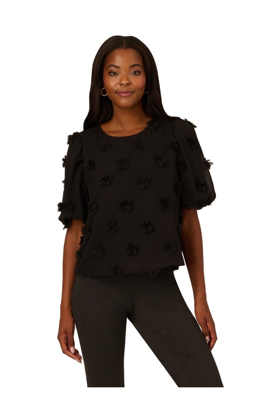 Add a fun dimensional moment to your outfit with this cute short sleeve top dotted with fluttery chiffon flower appliques. Balloon sleeves hit just above the elbow to complete the sweet, romantic feel of this blouse. A keyhole button closure at the back finishes the crew neck collar. Perfect for work and weekend style, you will love the way this charming top dresses up any look.