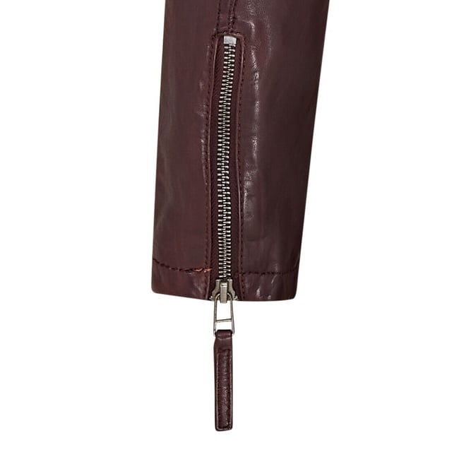 Maak kennis met ons prachtige leren bikerjack, compleet met een uitritsbare jersey capuchon voor extra veelzijdigheid. Dit jack is gemaakt van ultrazacht schapennappaleer en belichaamt de klassieke caf�racerstijl met een moderne twist. De YKK-ritssluiting aan de voorkant strekt zich uit tot een kraag met lipje die is vastgezet met een riem met gesp, terwijl tramlijnstiksels op de schouders en elleboogstukken de biker-esthetiek versterken. Vier zakken met ritssluiting bieden voldoende opbergruimte en de manchetten in handschoenstijl zijn verstelbaar voor een perfecte pasvorm. De royale capuchon kan eenvoudig worden verwijderd en de binnenkant is volledig gevoerd met poplin-stof met voor het gemak een extra met leer afgewerkte zak. Superzacht schapennappaleer, uitritsbare jersey capuchon, YKK-ritssluiting aan de voorkant met kraag met gesp, tramlijnstiksels op schouders en ellebogen, volledig gevoerd met een extra met leer afgewerkte binnenzak