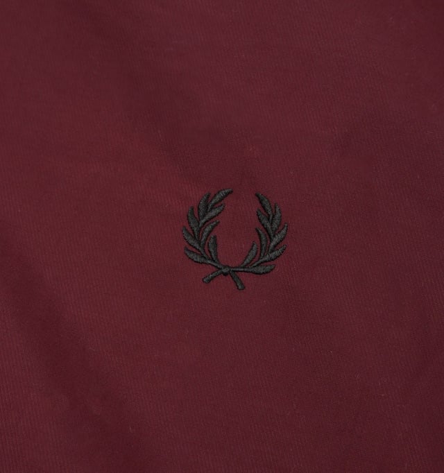 Veste à capuche Fred Perry matelassée Brentham pour homme en rouge  Fred Perry offre un style actualisé et intemporel et la veste à capuche matelassée Brentham ne fait pas exception. Alliant style sportif et élégance, cette veste de sport est fabriquée en sergé de nylon pur avec un rembourrage léger pour plus de chaleur. Capuche à cordon de serrage réglable, fermeture zippée à double sens, poches passepoilées sur le devant, poignets côtelés et ourlet avec double liseré contrastant. Finition avec l'emblématique couronne de laurier Fred Perry brodée sur la poitrine, lui donnant un look immédiatement reconnaissable.-Coupe Regular-Twill de nylon pur-Rembourrage léger-Capuche à cordon de serrage réglable-Fermeture éclair bidirectionnelle-Poches avant passepoilées-Poignets et ourlet côtelés-Détails à double liseré-Logo Fred Perry