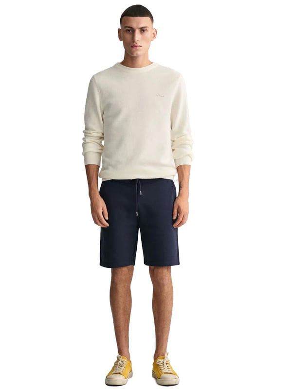 Estos clásicos pantalones cortos de chándal están confeccionados con una mezcla de algodón suave y diseñados para un ajuste regular. Con una cintura acanalada para mayor comodidad, el diseño incluye dos bolsillos frontales, un bolsillo trasero y una cintura con cordón. Para completar el look, los pantalones cortos están adornados con un pequeño escudo bordado en la pierna izquierda.