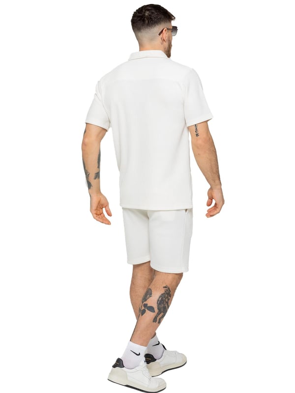 Elevate your summer style with our Enzo Milano Men's Outfit Set, including a textured ribbed revere shirt and relaxed fit shorts. Experience ultimate comfort with a button fastening and adjustable drawstring waistband, while looking effortlessly stylish with a revere collar and single back welt pocket. Made with premium fabric, this set is perfect for any occasion.