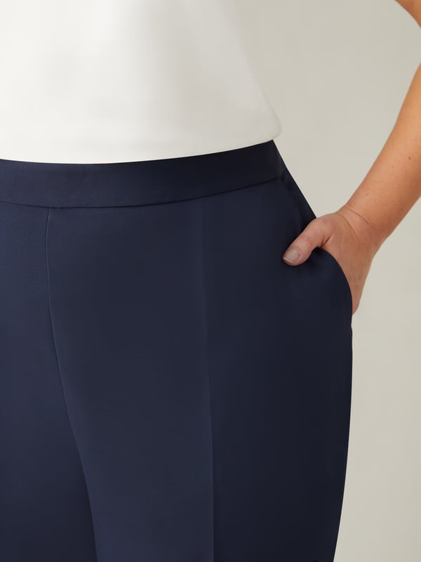 In classic navy, these trousers are cut from a woven fabric thats sturdy but comfortable to wear. With a flattering tapered leg, they have a tailored fit with side splits at the leg cuffs. A partially elasticated waist with a side zip closure adds comfort while ensuring the perfect fit, making these the perfect elevated trousers for any wardrobe.