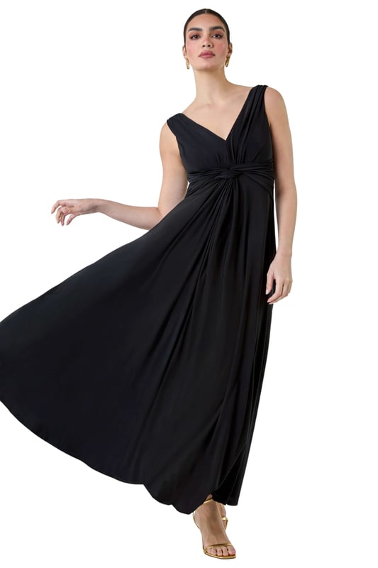 Plain Knot Front Maxi Dress from Roman. Turn heads in this luxuriously elegant knot front maxi dress. This exquisite sleeveless dress features a flattering v-neckline and a striking v-back detail, ensuring you make a sophisticated statement. With a fit and flare silhouette, this plain dress is fitted at the waist and flows into a floor-sweeping length, perfect for special occasions. The stretch jersey fabric drapes beautifully, while the knot detail at the waist adds an extra touch of glamour. Whether you're attending a wedding reception or a formal dinner, pair with strappy heels and a fascinator for a Summer wedding look.