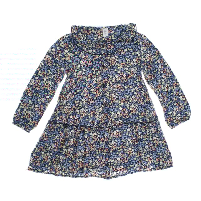 Vestido camisero de niña con un encantador estampado floral, ideal para un look fresco y primaveral. 

Confeccionado en tejido ligero, este vestido presenta un diseño de botones en la parte frontal que resalta su estilo clásico y funcional. 

Su cuello redondo con detalles de ribete añade un toque delicado, mientras que las mangas largas le aportan versatilidad para cualquier ocasión. 

La cintura ligeramente fruncida crea un sutil efecto de vuelo en la parte inferior, dándole movimiento y elegancia. 

Perfecto para eventos especiales o para el día a día, este vestido combina comodidad y estilo en una prenda encantadora.
 Composición: 100% Viscosa
 Cuidados:
- Lavar a máquina máx. 30ºC.
- Utilizar colores similares en el lavado.
- Evitar el uso de blanqueadores.
- Secar a baja temperatura.
- Planchar a baja temperatura.
- No lavar en seco.