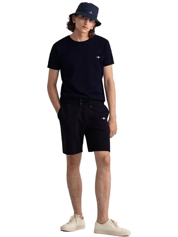 Gant introduces a mens t-shirt and shorts set with a small-scale embroidered shield graphic on the chest. Made of soft cotton and featuring a ribbed neckline, this tee showcases the iconic GANT logo. Crafted for everyday wear, the regular-fit tee is both comfortable and sustainable with Better Cotton. The included sweat shorts, also made of soft cotton blend, feature a ribbed waistband, three pockets, and a drawstring waist. The shorts are adorned with a small-scale embroidered shield graphic.