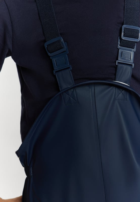 geen voering/geen voering, geen vulling, verstelbare elastische broekband 20cm  Maak kennis met een waterdichte tuinbroek voor kinderen met versterkte knieën en zitvlak voor duurzaamheid. Verstelbare bandjes met gespen zorgen voor een persoonlijke pasvorm, en de elastische taille en beenuiteinden zorgen voor comfort en flexibiliteit. Met reflecterende strips die zichtbaarheid garanderen en gelaste naden is dit pak perfect om buiten te spelen en te verkennen. Broek gemaakt van 3000 mm waterdicht materiaal. Dit product maakt deel uit van de Kidscollectie.  Regenbroek