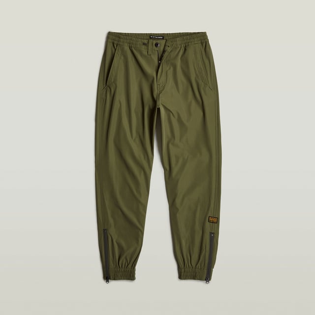 Zip fly, drawcord added. Inset pockets, single back pocket. Stretchable cuffs, relaxed width. Zipper at the lower leg. Pleats inner knee. Zip & button closure. Mid waist. Woven trainer RCT is designed in a loose fit with a relaxed cuff. Inset pockets are combined with a single pocket at the back. The zippers at the ankle add detail. 65% Polyester (Recycled), 35% Elastomultiester. Comfortable stretch. Tapered