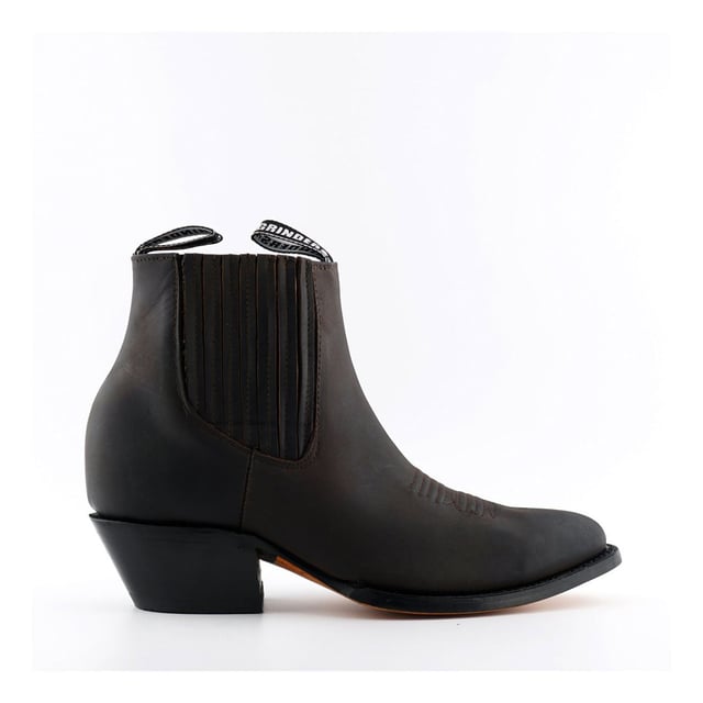 Este par de botines estilo western está fabricado íntegramente en cuero para lograr un aspecto y una sensación sofisticados. La parte superior es resistente a la abrasión para una mayor durabilidad y, para agregarle carácter, presentamos detalles de costuras intrincadas en la parte delantera. La parte delantera del zapato se completa con una puntera puntiaguda y los costados cuentan con una línea superior elástica, así como dos presillas con la marca para ponérselas fácilmente. La suela de este zapato tiene la marca del bulldog de Grinders y se ha unido con calor a una vira para brindarle a este zapato mayor resistencia y durabilidad. • Costura Goodyear • Parte superior de cuero • Forro de cuero suave • Tacones de cuero apilados • Suelas de cuero • Fabricado en México