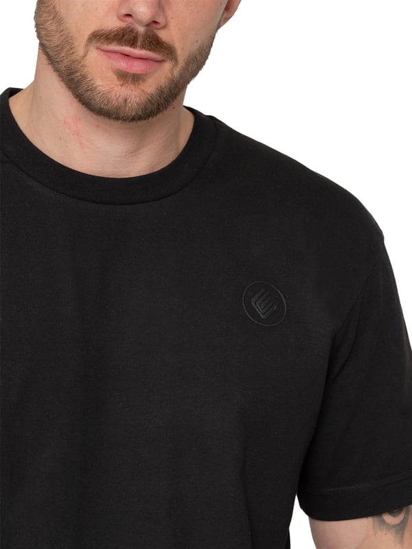 Presentamos la camiseta Enzo Oversized Relaxed Fit. Esta prenda versátil combina la comodidad con un estilo moderno y desenfadado. Con un cuello redondo clásico y un corte oversize relajado, es perfecta para llevar a diario. El detalle más destacado es la insignia de goma con el logotipo en la parte delantera, que añade un toque sutil pero elegante. Confeccionada en un tejido suave y transpirable,