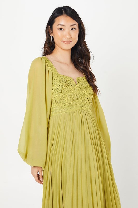 Exquisite lace bodice with intricate floral detailing
        Elegant square neckline for a sophisticated look
        Voluminous bishop sleeves add drama and flair
        Pleated chiffon skirt creates graceful movement
        Midi length perfect for formal occasions
    
    This stunning Coast dress combines timeless elegance with contemporary flair, making it an ideal choice for weddings, races, or any sophisticated soire. The lace bodice, adorned with delicate floral patterns, creates a captivating focal point, while the square neckline frames the dcolletage beautifully. The billowing bishop sleeves add a touch of romance and drama to the silhouette. The pleated chiffon skirt flows gracefully from the waist, offering both comfort and style as you move. To complete your ensemble, pair this dress with strappy metallic heels and delicate drop earrings. For a polished daytime look, layer with a tailored blazer and accessorise with a fascinator for the races. This versatile piece effortlessly transitions from day to evening events, ensuring you'll be the epitome of sophistication at any occasion.