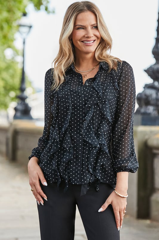 This one works as hard as you doAll-over spot print that's always on-trendGorgeous ruffle detail takes it from desk to dinner We've kept the sleeves sheer and added a cami for coverage Longline hem you can wear loose or tucked inIt looks so chic with cigarette trousers and courts