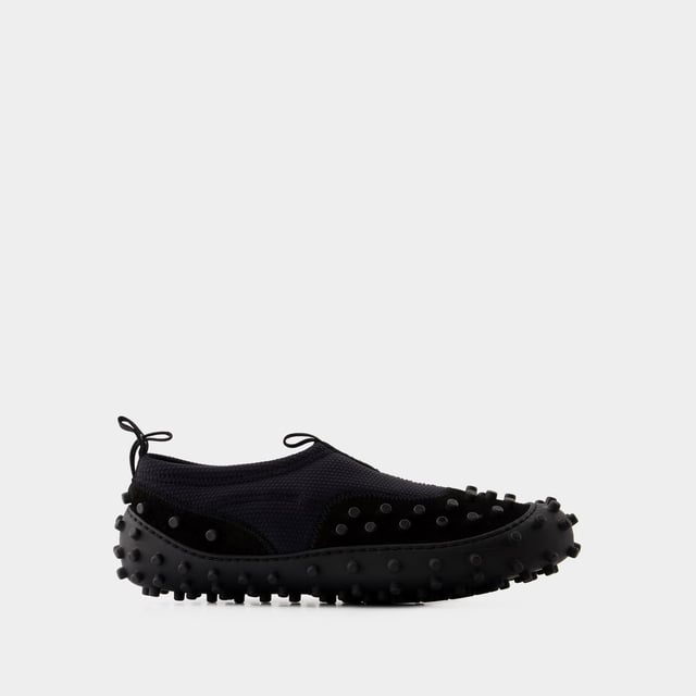 Dies sind die Millechiodi Sneakers von Sunnei, wo avantgardistisches Design auf zeitgemäßen Komfort trifft. Diese Sneakers verbinden mühelos einen avantgardistischen Stil mit moderner Praktikabilität, wobei das einzigartige Detail mit mehreren Schnürsenkeln für einen Hauch von Individualität sorgt. Für einen originellen Stil kombinieren Sie sie mit einer weiten Hose und einem übergroßen Grafik-T-Shirt. Diese unerwartete Kombination schafft einen topmodischen Look, der sich perfekt für einen Besuch auf statement bei der Eröffnung einer Kunstgalerie oder auf einer angesagten Party eignet. Sunnei Die Millechiodi Sneakers von brand's verdeutlichen das Engagement der Marke für Qualität und Mode, indem sie Ihnen eine unverwechselbare und vielseitige Wahl bieten, die mühelos modernen Charme mit Komfort und Eleganz vereint. Gehen Sie selbstbewusst und mit Ihrem persönlichen Sinn für Stil in diesen ikonischen Sneakers aus dem Haus und unterstreichen Sie Ihr einzigartiges Modebewusstsein. Farben: Schwarz - Black. Hauptmaterial: polyamide. Material Sohle: Gummi. Verschluss: einfach reinschlüpfen. Form der Kappe: mandel-förmig. Fällt normal aus - Sizing: Width: 10. Height: 2. Length: 26.