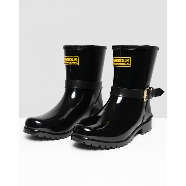 Botas mugello negras Barbour International para mujer, fabricadas en caucho y suela de caucho. Presentan: acabado de alto brillo, suela de perfil bajo, marca Barbour, hebilla decorativa y estilo motero.