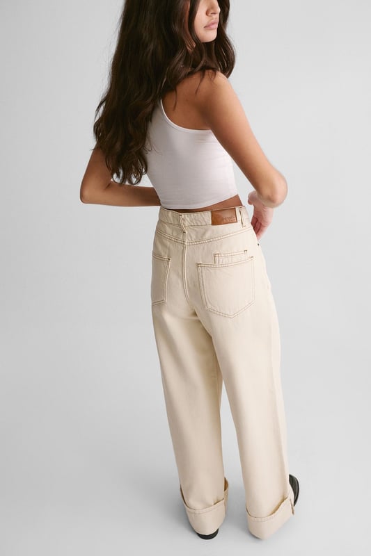 Wide-leg silhouette for a relaxed, on-trend look
        Distinctive turn-up cuffs adding a stylish twist
        High-waisted design for a flattering fit
        Classic five-pocket styling for practicality
        Versatile denim fabric suitable for various casual occasions
    
    The Denim Turn Up Jean from NastyGal presents a fresh take on a wardrobe staple. These jeans manifest a perfect blend of comfort and style, ideal for the fashion-forward individual seeking a versatile piece. The wide-leg silhouette paired with the high-waisted design creates a striking profile, while the turn-up cuffs add a touch of casual sophistication. Style these jeans with a fitted white vest top and chunky loafers for an effortlessly cool daytime look. For a more laid-back vibe, pair with a loose-fitting tee and trainers. These jeans are perfect for casual outings, family gatherings, or relaxed weekends about town. Their adaptable nature allows for easy transition from day to night - simply swap your flats for a pair of statement heels and add a blazer for an evening-ready ensemble. The Denim Turn Up Jean is a must-have piece that will quickly become a cornerstone of your casual wardrobe.