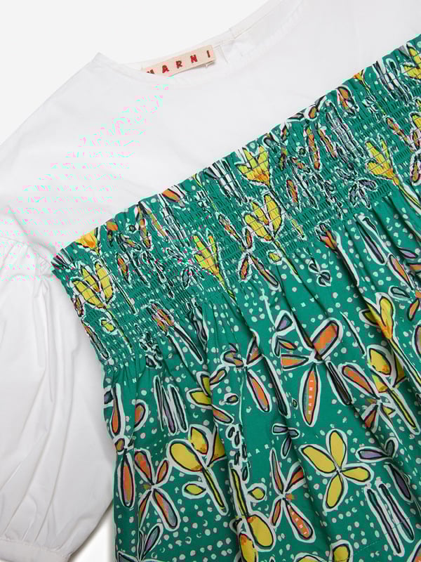 Marni's fresh invigorative perspective is embodied in this girls shirt. Inspired by the early noughties, it showcases poplin balloon sleeves with all-over Carioca graphics and a comfortable elastic. It is the perfect summer garment to be adored.   Button Closure On Back 100% Cotton