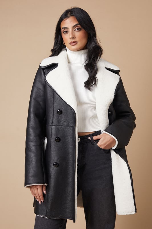 Double-breasted design for a classic, sophisticated look
        Contrasting shearling collar and lining for added warmth and style
        Oversized lapels create a dramatic, fashion-forward silhouette
        Multiple buttons for adjustable closure and fit
        Mid-thigh length offers versatile coverage for various outfits
    
    This double-breasted shearling coat from Oasis is the perfect blend of style and cosiness for the cooler months. The contrasting shearling collar and lining not only provide extra warmth but also add a luxurious touch to the overall design. Style this coat with a crisp white turtleneck and dark trousers for a chic daytime look, or throw it over a floral dress for a pretty evening ensemble. The versatile mid-thigh length makes it suitable for various occasions, from casual weekend outings to family gatherings. For a complete look, pair with ankle boots and a cross-body bag. This coat is an investment piece that will keep you looking stylish and feeling snug throughout the autumn and winter seasons.