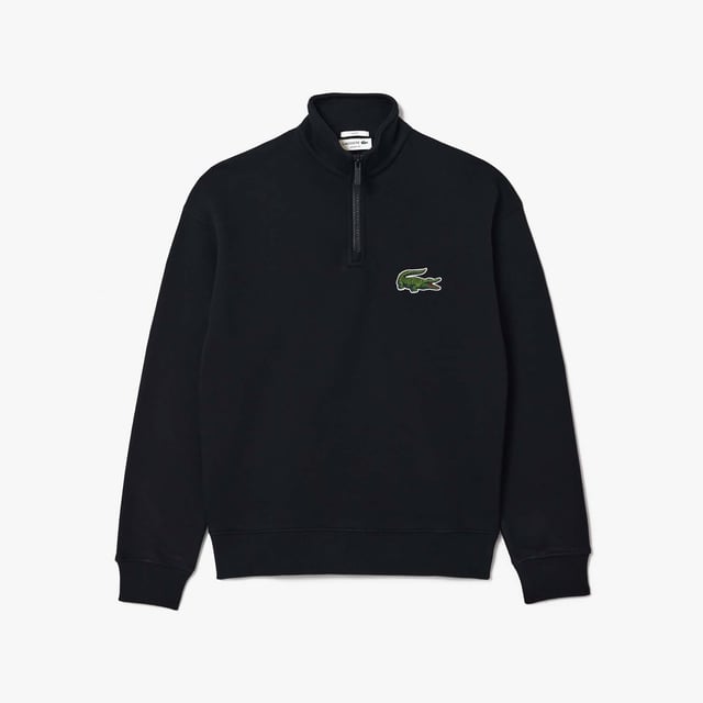 Unisex Lacoste Loose Fit High Neck Sweatshirt in Black. Finest materials, brand’s singular expertise. The perfect expression of Lacoste’s timeless wardrobe.- Loose fit is loose ease on body and sleeves, lower shoulders and armholes.- Half zipped sweatshirt in organic heavy French terry with big croc 80' on chest.- Unisexe.- Zipped high collar in shell fabric.- 7cm iconic original badge crocodile.- 3cm green crocodile at under middle back collar. Material: 100% Organic Cotton. Ref: SH0069031.