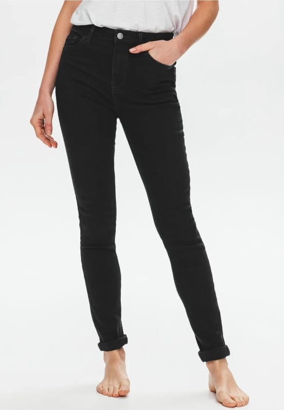 Deze zwarte jeans met hoge taille heeft gerecyclede vezels. Skinny, voor een slank en leggy effect. Van zacht denim. Rekbaar. Riemlussen. Stud knoop, metalen rits. Metalen klinknagels. Een favoriet in je garderobe!