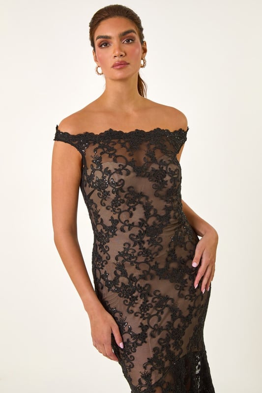 Lace Scallop Edge Front Split Maxi Dress from Roman. Get ready to make a statement in our stunning lace maxi dress. The feminine bardot neckline is adorned with delicate scalloped lace details, adding a touch of elegance to the look. Crafted from a stretch woven fabric, this bodycon dress hugs your shape beautifully and finishes at a flattering maxi length with a mermaid edge and front split for added drama. Pair with heels and a bolero for an unforgettable look!