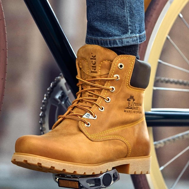 Steigen Sie mit Stil und Komfort aus mit Panama Jack-Stiefeln. Egal, ob Sie über schroffe Landwege wandern oder durch städtische Straßen navigieren, der originale Panama Jack 03 C1 Herren-Schnürstiefel ist Ihr perfekter Begleiter. Diese Stiefel zeichnen sich durch ein klassisches Design mit einer schlichten runden Spitze und einem dunkelbraunen, gepolsterten Lederkragen aus und strahlen zeitlose Eleganz aus. Die kontrastierenden roten und gelben Schnürsenkel sorgen für einen Farbtupfer, während die genähte karamellfarbene Commando-Sohle für Strapazierfähigkeit und Stabilität in jedem Gelände sorgt. Für die Herren sind die Schnürstiefeletten Tan Panama Jack 03 für Herren so konzipiert, dass sie den Elementen standhalten. Mit einem wasserdichten, glatten Nubuk-Obermaterial, einem weich gepolsterten Knöchelschaft und einem warmen Futter halten diese Stiefel Ihre Füße kuschelig und trocken. Das geprägte Logo an der Ferse und die silbernen sechseckigen Metallösen verleihen ihrem robusten Charme einen Hauch von Raffinesse. Hauptmerkmale: Klassisches Design: Die Panama 03-Stiefel vereinen Design, Qualität und Komfort nahtlos und bieten eine zeitlose Ästhetik für Männer und Frauen. Vielseitiger Tragekomfort: Egal, ob Sie die Straßen der Stadt erkunden oder Bergpfade erobern, diese Stiefel sind perfekt für alle Ihre täglichen Abenteuer. Wasserdichte Konstruktion: Diese Stiefel sind aus wasserdichtem Vintage-Nappaleder mit Lederfutter gefertigt und sorgen dafür, dass Ihre Füße bei jedem Wetter trocken und bequem bleiben. Anatomische Unterstützung: Genießen Sie verbesserten Komfort und Hygiene mit der anatomisch geformten Innensohle, die eine perfekte Passform für Ihre Füße bietet. Langlebig und rutschfest: Die Gummiaußensohle bietet Flexibilität, Haltbarkeit und rutschfeste Traktion und sorgt für Stabilität auf verschiedenen Oberflächen. Hergestellt in Spanien: Mit einer Schafthöhe von 18 cm werden diese Stiefel fachmännisch in Spanien gefertigt, um höchste Handwerkskunst und Qualität zu gewährleisten. Schlüpfen Sie in die Stiefel von Panama Jack und erleben Sie die perfekte Mischung aus Stil, Haltbarkeit und Komfort für Ihre alltäglichen Abenteuer. Diese Stiefel wurden für diejenigen entwickelt, die Wert auf Qualität und Handwerkskunst legen. Sie sind Ihr vertrauenswürdiger Begleiter, wohin auch immer Ihre Reise Sie führt.