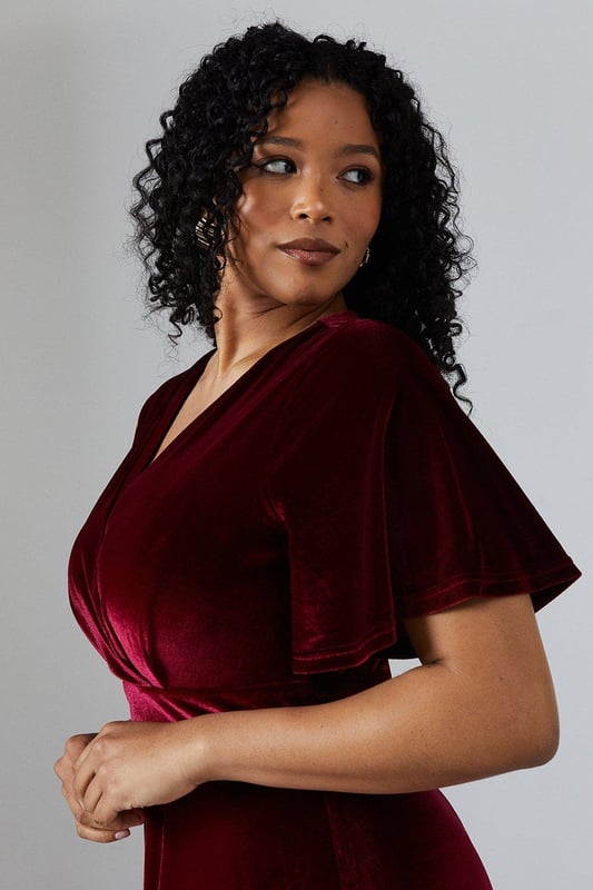 Luxurious velvet fabric for a sumptuous look and feel
        Flattering V-neckline to enhance the dcolletage
        Angel sleeves for a romantic and ethereal touch
        Floor-sweeping maxi length for a dramatic silhouette
        Fitted waist to accentuate the figure
    
    This enchanting V Neck Angel Sleeve Velvet Bridesmaids Maxi Dress from Coast is the epitome of sophistication and grace. Perfect for the bridal party, this gown is designed to complement the bride while ensuring you stand out in your own right. The sumptuous velvet fabric drapes beautifully, creating a fluid silhouette that moves elegantly as you walk. The angel sleeves add a whimsical touch, while the V-neckline draws attention to the dcolletage. The fitted waist cinches in to create an hourglass shape, flowing into a full-length skirt that skims the floor. Pair with delicate strappy heels and minimal jewellery to let the dress take centre stage. This gown is versatile enough to be worn again for other formal occasions, making it a treasured addition to your wardrobe long after the wedding bells have rung.