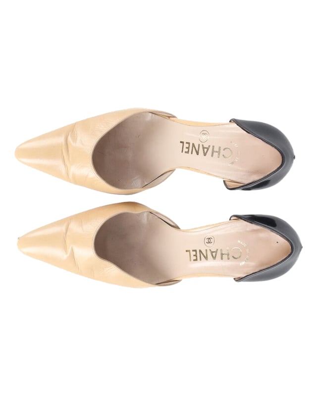 VINTAGE, UVP WIE NEU  
Diese schwarzen und beigen Pumps aus dem Hause Chanel sind wahrhaft elegant und anmutig. Sie bestehen aus Leder und Lackleder und präsentieren zweifarbige Absätze. Sie sind im Slipper-Stil mit spitzen Zehen gefertigt. Tragen Sie sie sowohl zu formellen als auch zu lässigen Outfits!  
Chanel Classic Zweifarbige Pumps aus beigem Leder  
Farbe: beige  
Material: Leder  
Größe: EU38  
Zustand: gut  
Abnutzungsspuren: Falten im Obermaterial und abgeriebene Sohlen  
SKU: 199699