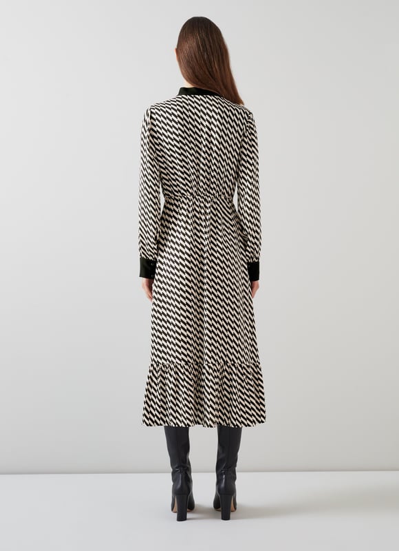Effortless sophistication with the Bridget graphic print dress in timeless black. This smart casual piece, crafted from high-quality viscose, features a geometric design, adjustable neck tie, and convenient pull-on style. Perfectly pairs with sleek boots or classic heels for a refined look.