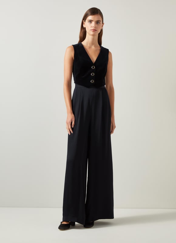 Be the center of attention with the Carine waistcoat culotte jumpsuit, ideal for evening events. In sleek black, this cotton blend jumpsuit boasts a v-neck, sleeveless design, mixed media details, and convenient pockets with a back zip. Combine it with statement heels and a clutch for an effortlessly stylish appearance.