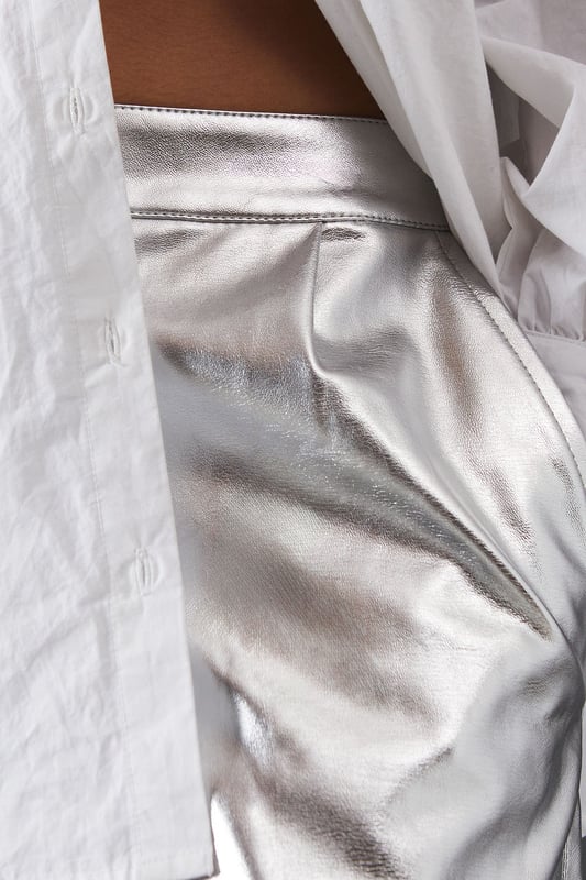 Eye-catching metallic finish for a bold statement
        Wide leg silhouette for a comfortable and trendy fit
        High-waisted design accentuates the waistline
        Front zip and button fastening for a secure fit
        Versatile style suitable for various occasions
    
    Make a dazzling entrance with these striking metallic wide leg jeans from Warehouse. Perfect for those who dare to stand out, these trousers combine comfort with high-impact style. The wide leg cut offers freedom of movement while creating a fashionable silhouette. For a night out on the town, pair these show-stopping trousers with a crisp white shirt, leaving it partially unbuttoned for a relaxed yet chic look. Add some platform sandals to elongate your legs and complete the ensemble with statement earrings. Whether you're hitting the dance floor or enjoying drinks with friends, these jeans will ensure you're the centre of attention. Their versatility also allows for more casual styling - try pairing with a simple black tee and trainers for an effortlessly cool daytime look that transitions seamlessly into evening wear.