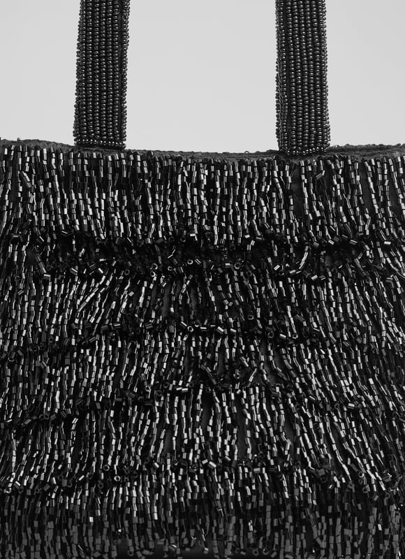 Shine in the spotlight with the dazzling Etsy clutch bag. Hand-beaded with intricate black crystals on mesh, this textured piece is lined with cotton for a luxurious touch. Perfect for evening events, pair the beaded bag with a sleek gown or tailored jumpsuit.