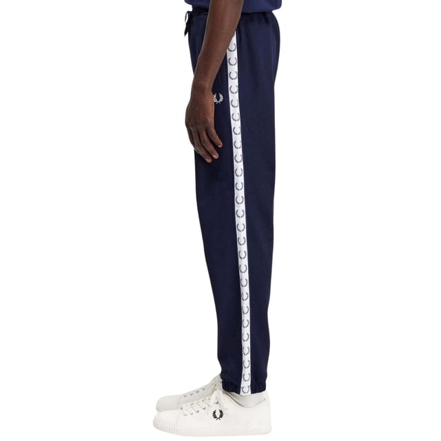Marineblaue Jogginghose mit Fred Perry-Logo, Markenlogo auf dem linken Bein, elastische Taille und Manschetten, elastische Taille und Bein, 46 % Baumwolle, 54 % Polyester, hergestellt in Portugal, blaue Jogginghose