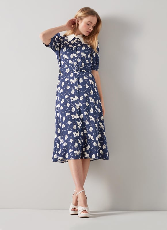 A beautiful spring dress in a super-fun and kitsch pop-art print, our Valerie shirt dress is a great everyday style. Crafted from silky fabric in a navy and cream 1960's lock and heart print reimagined from vintage archives, it has a Seventies-inspired contrast collar, puff shoulders, short sleeves, cream buttons, a buckle belt and a midi-length skirt. Wear it with a pair of platform heels for spring occasions.