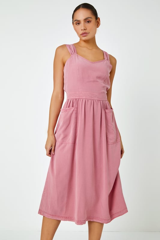 Dyed Strappy Pocket Dress from Roman. It's time to refresh your denim collection by adding this statement detail fit and flare midi dress to your summer wardrobe! This classic feminine piece features a sweetheart halter-neck into back tie detail and front pockets. This timeless one-piece looks great with trainers for an effortless daytime look, alternatively paired with wedges and a sun hat for those stylish city holiday summer breaks abroad.